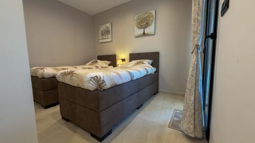 Guest bedroom with two single box-spring beds and terrace access